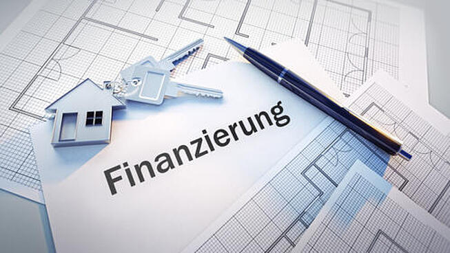 Baufinanzierung in MV Bild mit Finanzierung berechnen. Kugelschreiber und Papier auf dem Finanzierung steht